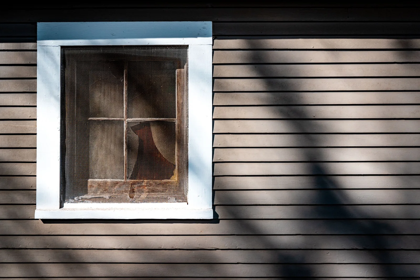 Fenêtre de toit avec moustiquaire velux, vue rapprochée sur le cadre et la toile dans des combles lumineux